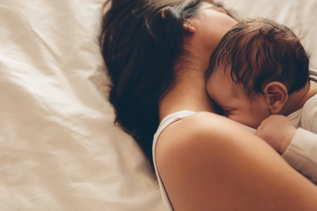 Bebê dormindo abraçado com a mamãe